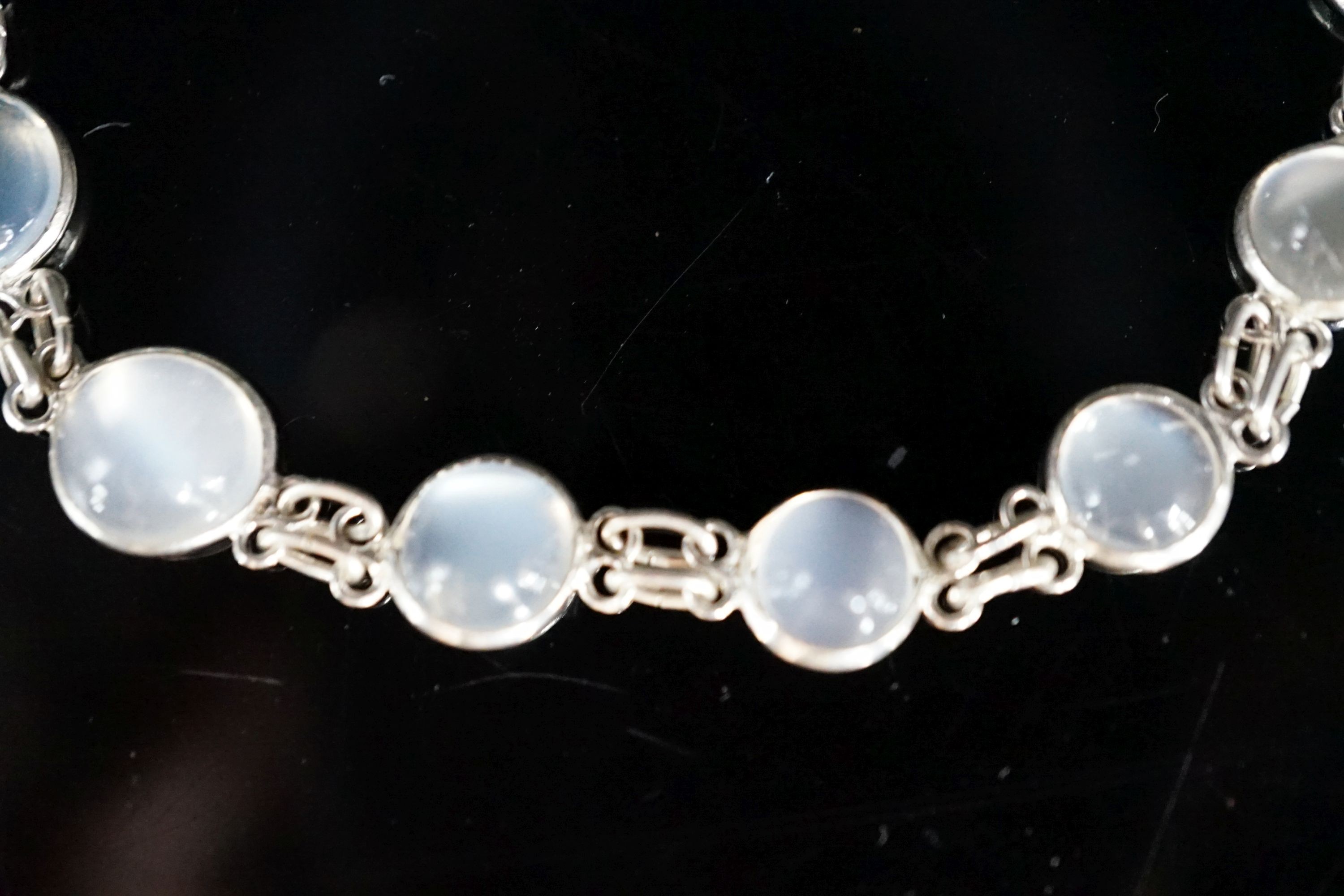 A modern (1980's) white metal and graduated moonstone set bracelet, 17cm.